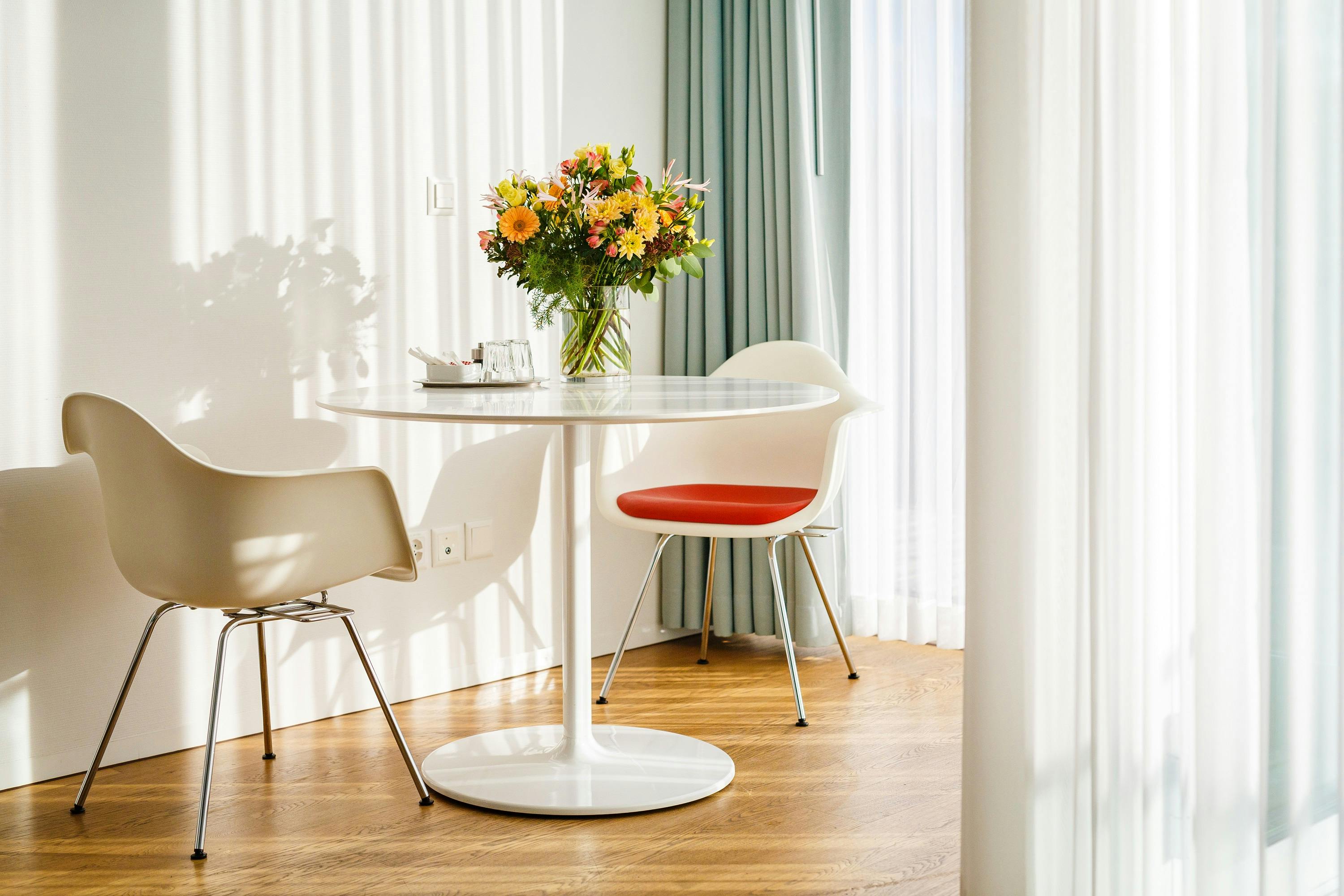 Heller Essbereich mit modernem Tisch, Stühlen und Blumenstrauß