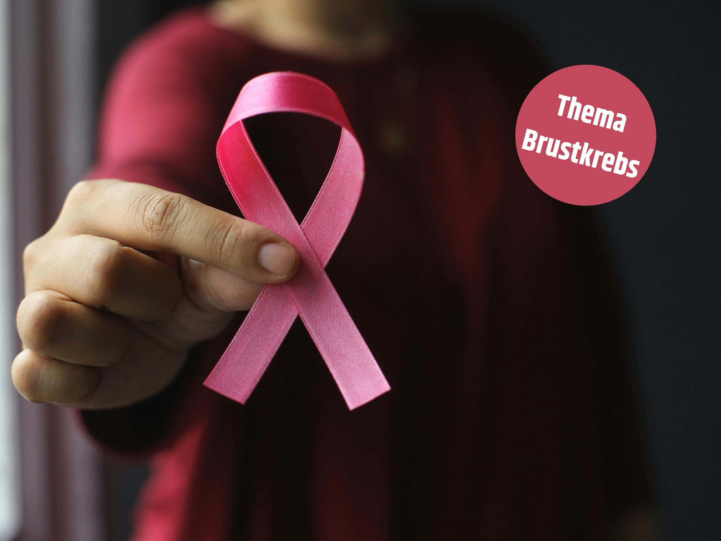 Person hält rosa Brustkrebs-Bewusstseinsband