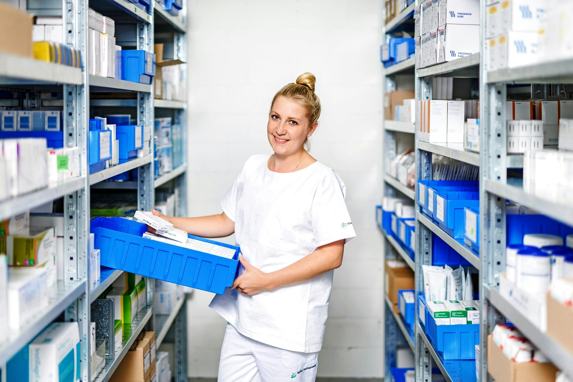 A pharmacist sorts medicines in a warehouse.
